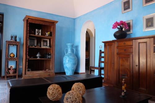 a living room with blue walls and a vase at Dammuso Il Sogno in Scauri