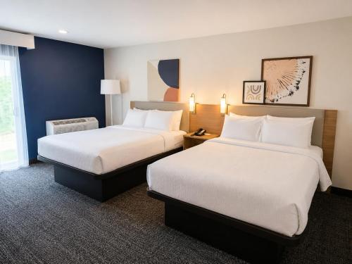 a hotel room with two beds and a window at Spark By Hilton Lake George Outlets in Lake George