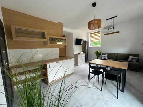 a kitchen and dining room with a table and chairs at Wisła Apartament Gór-SKI z jacuzzi in Wisła