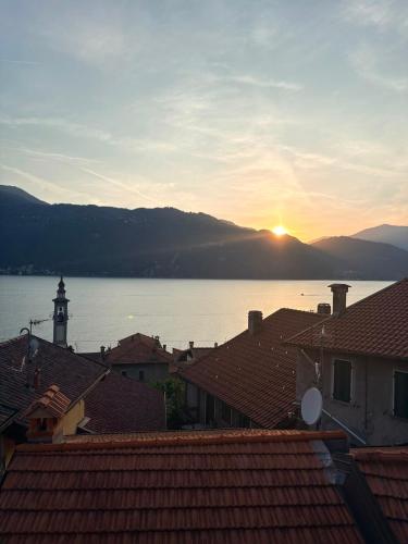a view of a town with the sun setting over the water at Olcium Holiday Rooms in Mandello del Lario