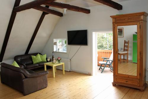 a living room with a couch and a tv at Altes Rauchhaus in Ebstorf