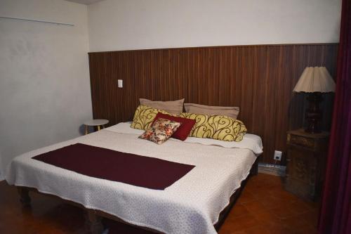 a bedroom with a large bed with a wooden headboard at Departamento Loro in Manzanillo