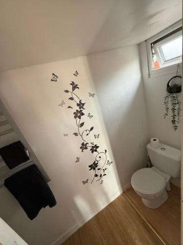 a bathroom with a toilet and butterflies on the wall at The Butterfly in Leysdown-on-Sea