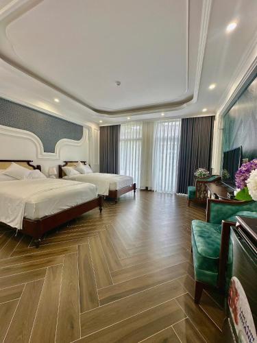 a hotel room with two beds and a couch at Vững Mạnh Hotel in Ðồng Ky