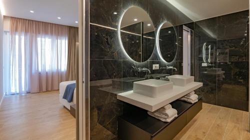 a bathroom with two sinks and a large mirror at GG Spagna Luxury Suites in Rome