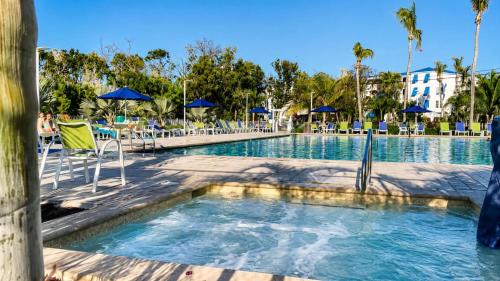 a pool at a resort with chairs and umbrellas at Luxurious 2BR 2BA Ocean Pointe Condo Tavernier Fl in Tavernier