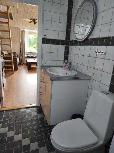 a bathroom with a toilet and a sink and a mirror at The Colored Butterfly in Månstad