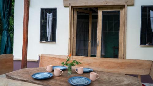 a wooden table with blue plates and cups on it at El Cerrito in Puerto Jiménez