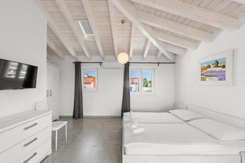 a white room with a couch and a tv at Villas Marisol in Premantura