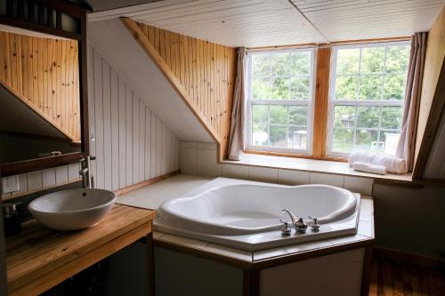a bathroom with a large sink and a window at Manoir Charlevoix in La Malbaie