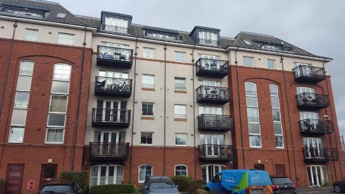 un gran edificio con coches estacionados frente a él en Edinburgh City Deluxe Apartment, en Edimburgo