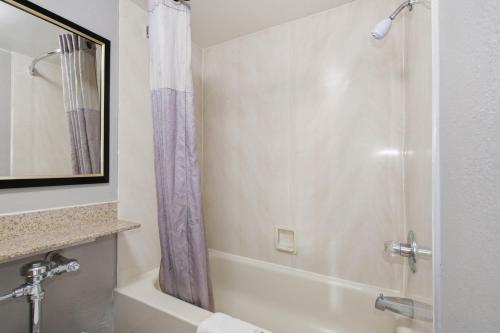 a bathroom with a tub and a shower with a shower curtain at Motel 6-Washington, DC in Washington, D.C.