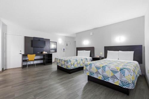 a hotel room with two beds and a desk at Motel 6-Washington, DC in Washington, D.C.