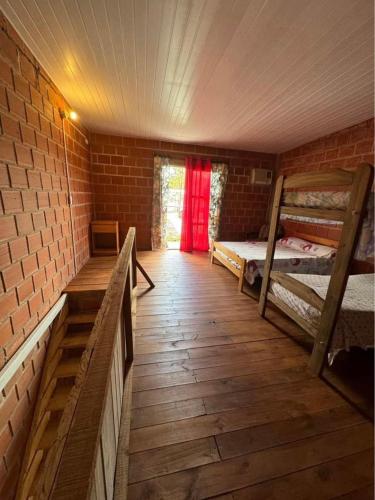 a room with two bunk beds and a red curtain at Cabañas Sagrado Corazón in Ituzaingó