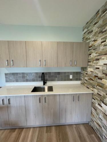 a kitchen with wooden cabinets and a sink at Home Inn & Suites Regina Airport in Regina