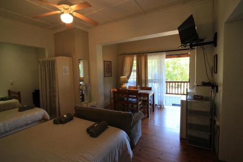 a living room with two beds and a couch at Dempsey's Self-Catering Guest House in Port Elizabeth