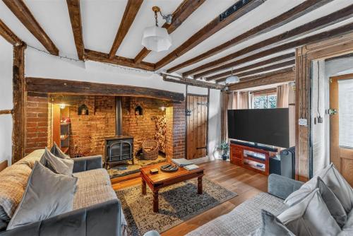 a living room with a couch and a television at Ye Olde Cottage in Crawley
