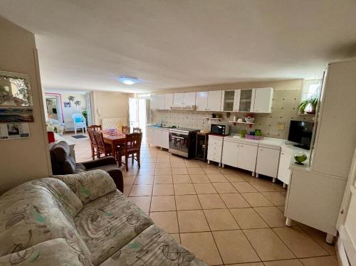 a kitchen and living room with a couch and a table at Dimora Giovanna in Poggiardo