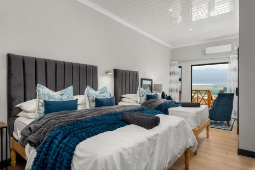 a bedroom with two beds with blue pillows at Ukholo Lodge in Citrusdal