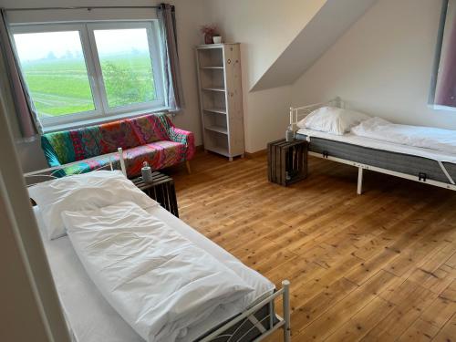 a dorm room with two beds and a couch at Admiralshütte XXL - für 12 Personen zwischen Dornumersiel und Bensersiel in Dornum