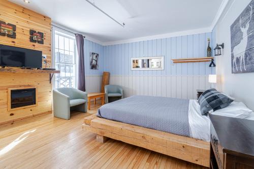a bedroom with a bed and a fireplace and a tv at Manoir Charlevoix in La Malbaie