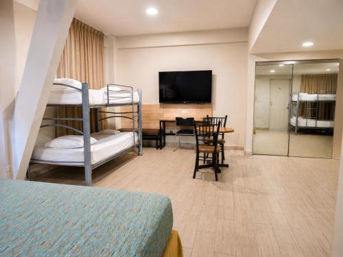 モンテレイにあるHotel Son- Mar Monterrey Centroの二段ベッド2台とダイニングルームのある寝室