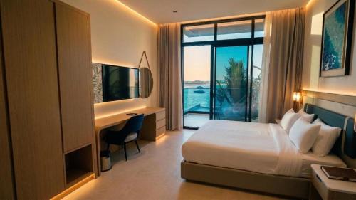 a hotel room with a bed and a desk and a window at V Beach in Jeddah