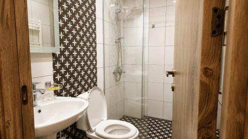 a bathroom with a sink and a toilet and a shower at Hotel Gold Kazbegi in Kazbegi