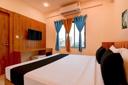 a bedroom with a bed and a tv and a window at Hotel O NamaStay in kolkata