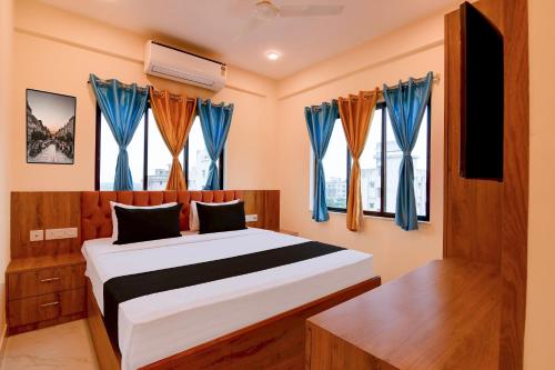 a bedroom with a bed with blue curtains at Hotel O NamaStay in kolkata