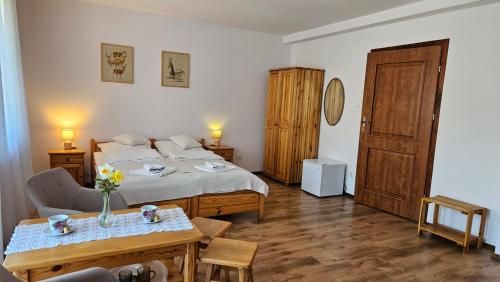 a bedroom with a bed and a table with flowers on it at Pensjonat Fluder in Jaszczurowa