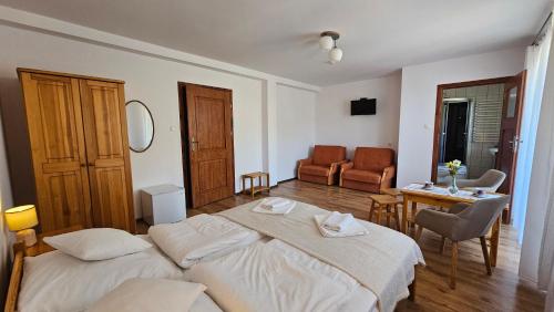 a bedroom with two beds and a table and chairs at Pensjonat Fluder in Jaszczurowa