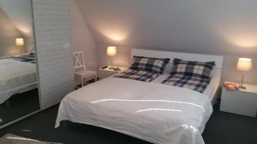 a bedroom with a white bed and two pillows at Direkter Blick auf´s Wasser in Fahrdorf