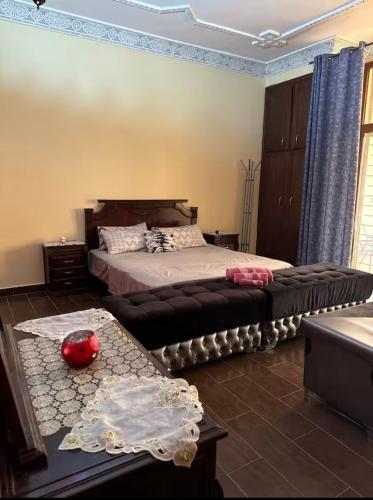 a bedroom with a large bed and a table at Ferme Paradiso, Route de Jerada, Sidi Moussa Lemhaya, Oujda in Oujda