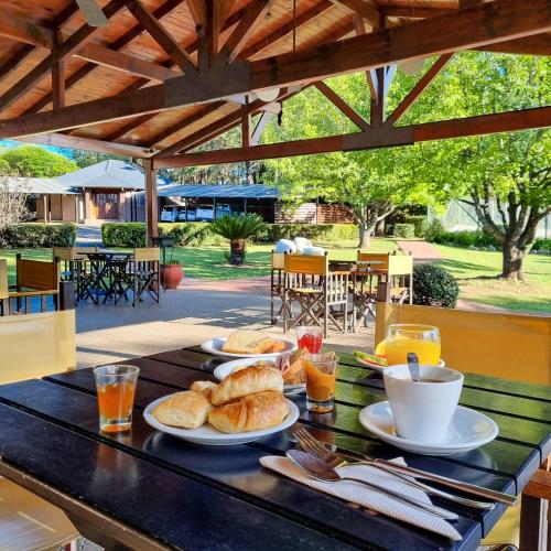 a table with plates of food on top of it at Berna Hotel & Spa in Villa General Belgrano