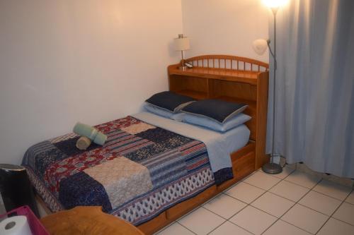 a small bedroom with a bed with blue pillows at Miami Drip Star Life Hostel in Parkway Regional Medical Center Heliport