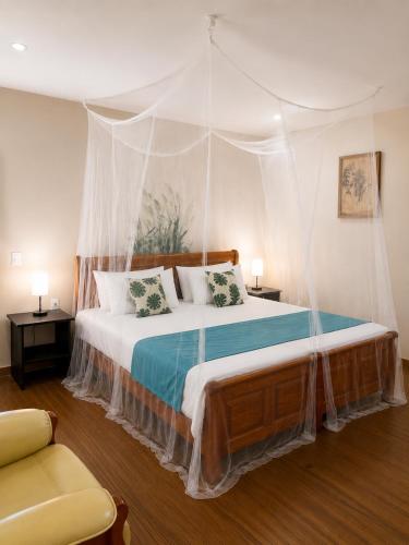 a bedroom with a bed with a canopy at Rancho el Sobrino in Sabana Westpunt