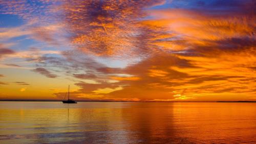 a sail boat on the water with a sunset at Key Largo 2BR 2BA Oceanfront with Pool in Tavernier