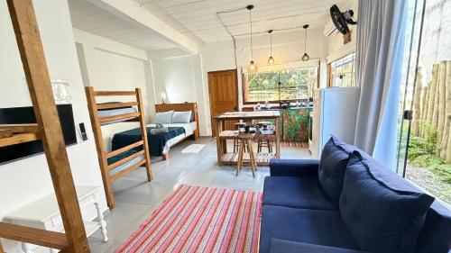 a living room with a blue couch and a table at Makai Suites in Ubatuba