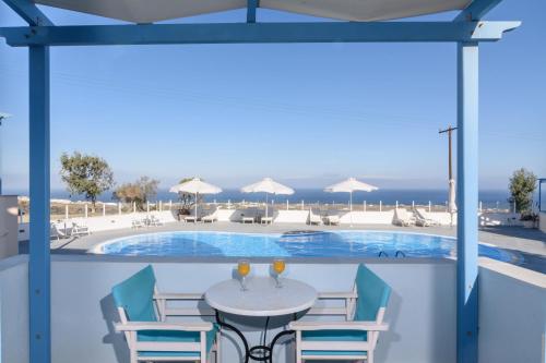 a patio with a table and chairs and a swimming pool at Maria's Place - Adults Only in Oia