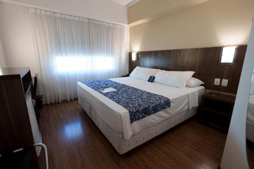 a bedroom with a large bed in a room at Firenze Business Hotel in Palhoça