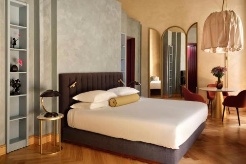 a bedroom with a bed and a table and chairs at Hotel Urbana, a Tribute Portfolio Hotel in Rome