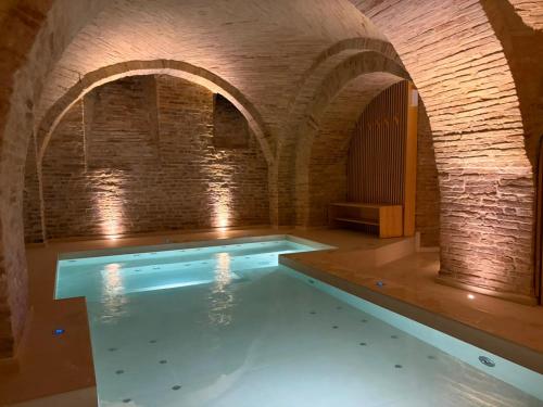 an indoor swimming pool with a brick wall at Palazzo Cortesi Boutique Hotel in Macerata