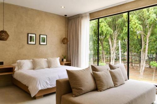 a bedroom with a bed and a couch and a window at Sweven Hotel Boutique in Guadalajara