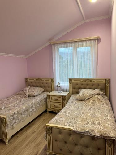 two beds in a bedroom with pink walls at Green House in Dilijan