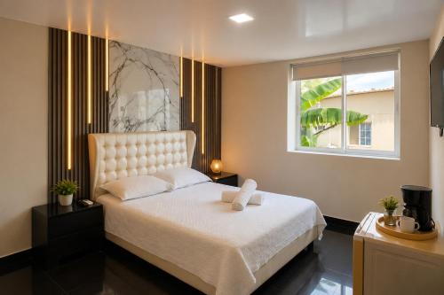 a bedroom with a white bed with a window at Ocean Blue Beach in San Andrés