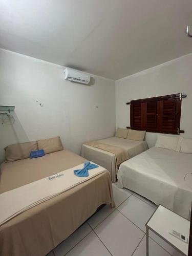 a room with three beds and a table at Casa de Praia Recanto Flecheiras in Trairi