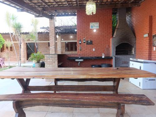 a large wooden table in front of a brick building at Casa de Praia Recanto Flecheiras in Trairi