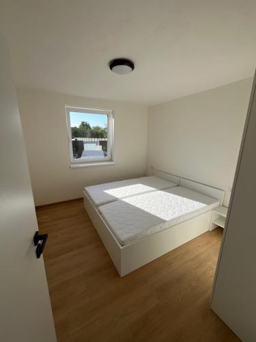 a white bedroom with a large bed in it at Hakro Jevisovka in Jevišovka