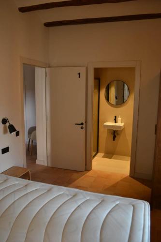 a bedroom with a white door and a mirror at Can Hortafa in Tortellá